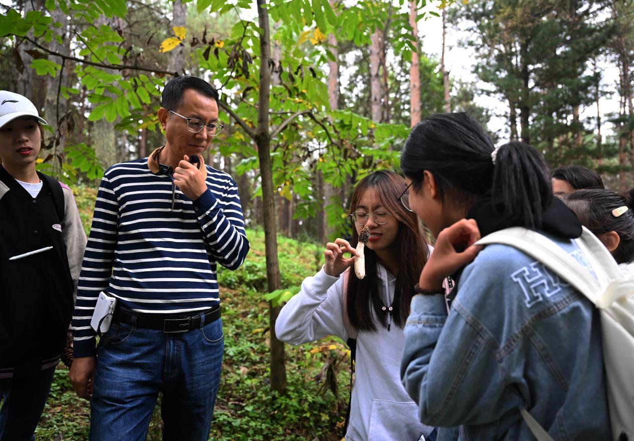 王占斌老師給同學(xué)們講解辨識(shí)蘑菇。（學(xué)校供圖）.jpg