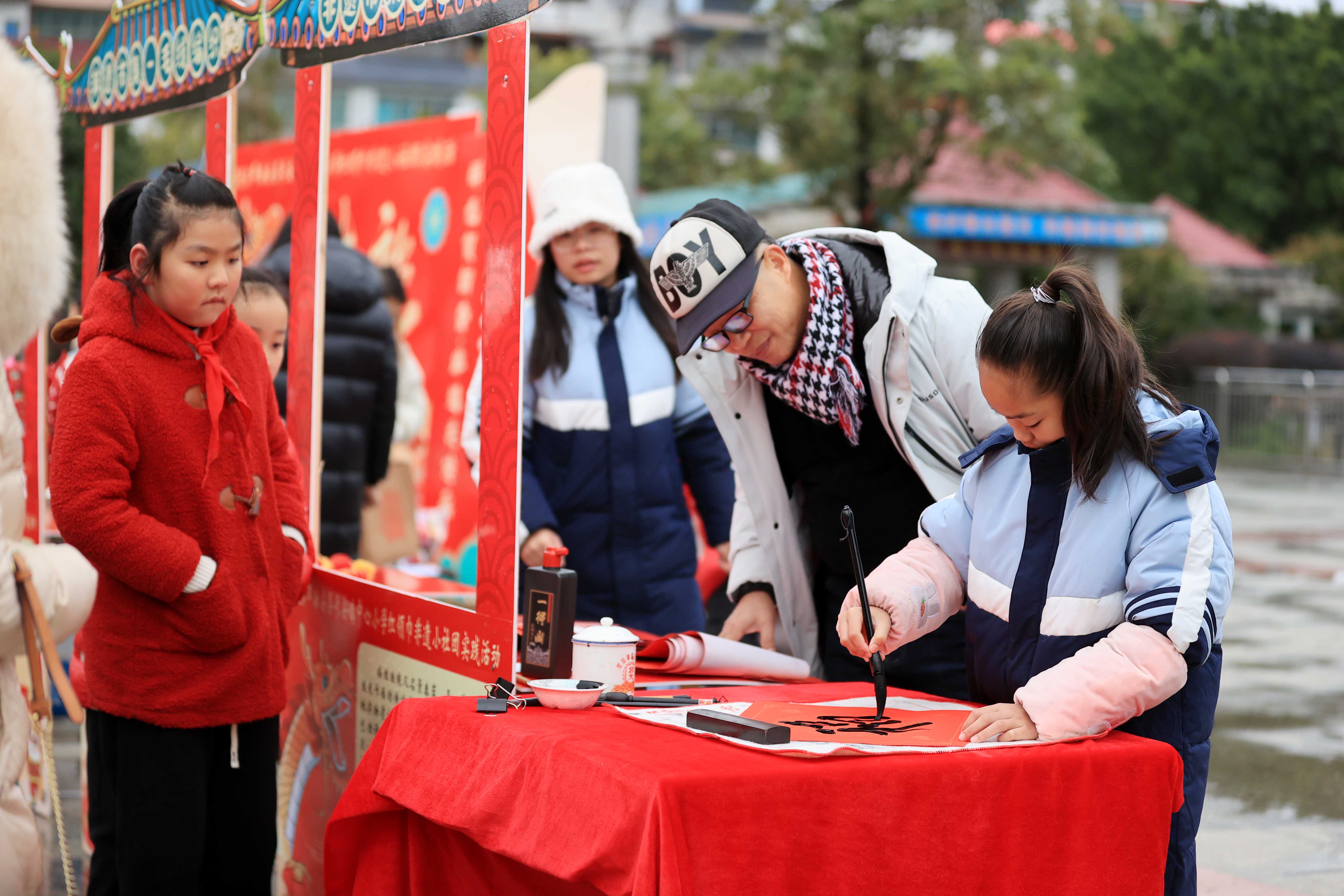 圖10：1月20日，在廣西柳州市融安縣長安廣場，一名小學(xué)生在書寫福字，準(zhǔn)備贈(zèng)送市民。（譚凱興 攝）.JPG